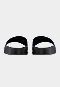 Ζευγάρι ανοικτών σανδαλιών με πίσω μέρος, σε σκούρο μπλε και μαύρο, με παχιές σόλες, απεικονιζόμενο από μπροστά σε λευκό φόντο.