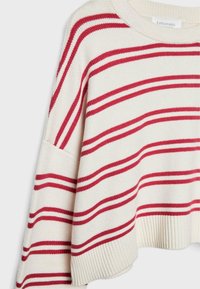 Gestrickter Pullover in Creme mit breiten, abwechselnden roten Streifen. Gerippter Saum und übergroße Passform mit breiten, herabgesetzten Schultern.