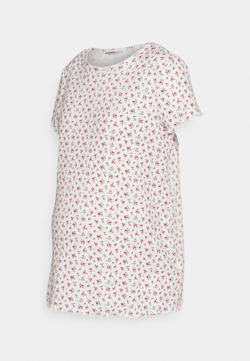 Top curto de mangas curtas em branco com um padrão floral com flores vermelhas. Decote redondo, corte descontraído e detalhe de bainha desfiada.