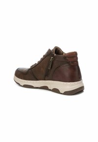 Scarpe alte in pelle marrone con zip laterale, dettagli testurizzati e suola di colore chiaro a contrasto. Punta arrotondata e collo imbottito.