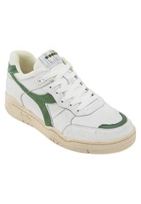 Zapatillas blancas con detalles en verde, cuero texturizado y malla. Presentan un acolchado en el collar, cordones planos y una suela de goma.