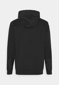 Sweat à capuche noir à manches longues avec poignets côtelés, détails en patch sur les coudes, et une capuche en tissu lisse vu de dos sur un fond blanc.