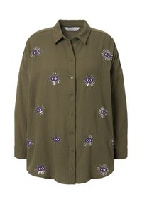 Chemise olive en tissu texturé avec des broderies violettes en forme d'œil et des éclats d'argent tout au long. Coupe décontractée, manches longues.