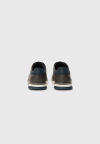 Brown leather shoes with a low profile, featuring a navy accent at the heel and a white midsole with stitching detail.