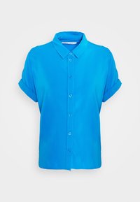 Chemise bleu vif à manches courtes avec boutons, poignets repliés et col classique, présentée sur un fond blanc uni.