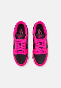 Nike-sneakers med svart läderutsida och klara rosa detaljer, med runda skosnören, perforerat tåområde och logodetaljer på tungan.