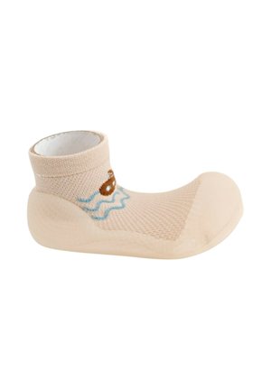 Zapato de bebé beige con suela blanda y diseño de calcetín hasta el tobillo con un pequeño barco y un patrón de olas azules en el lateral.
