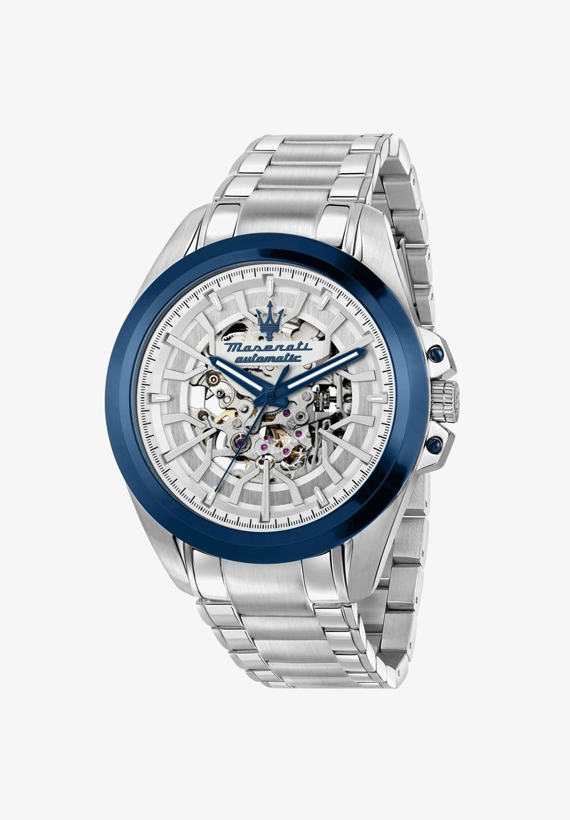 Montre-bracelet automatique pour homme Maserati avec bracelet en métal argenté, lunette bleue, cadran squelette, et engrenages et vis visibles.