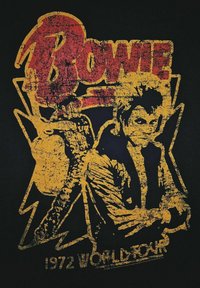 Černé tričko s opotřebovanou žlutou a červenou grafikou postavy a blesků, s textem "BOWIE" a "1972 WORLD TOUR".