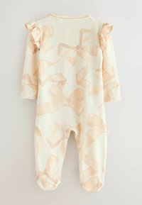 Gaisas krējuma krāsas kombinezons ar garām piedurknēm, rotāts ar atkārtotu gaiši rozā lentīšu rakstu, ar volānu plecu akcijām un aizvērtām pēdām.