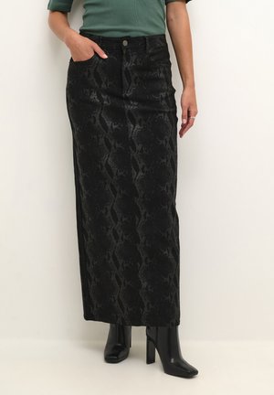 Black, long denim skirt featuring a snake print pattern, front pockets, and a fitted waist with a button closure; paired with black heels.