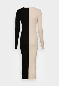 Abito a maglia a coste con maniche lunghe, caratterizzato da un design bicolore che si divide tra il nero e il beige. Silhouette aderente, tessuto morbido.