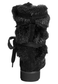 Czarny zamszowy botek za kostkę z dodatkami z sztucznego futra, zaokrąglonym noskiem i płaską podeszwą, wiązany z tyłu czarnymi sznurowadłami z tkaniny.