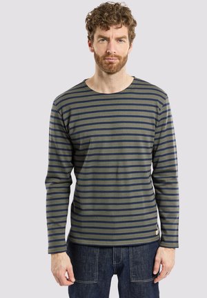 Langärmliges Hemd aus olivgrünem Baumwollstoff mit navyblauen horizontalen Streifen, runder Halsauschnitt und einem kleinen Logo-Patch am Saum.