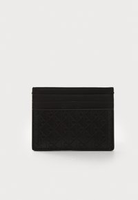 Porte-carte noir en cuir texturé présentant un motif géométrique avec des logos embossés, trois emplacements pour cartes et un design minimaliste.