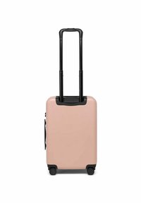 Valise rigide de couleur rose doux avec une poignée noire rétractable, quatre roues et une surface texturée. Dispose d'une poignée latérale pour un soulèvement facile.