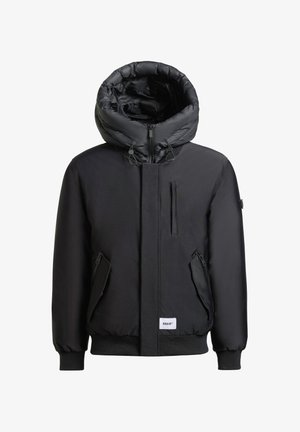 Giacca imbottita nera con un ampio cappuccio, zip frontale e molteplici tasche con zip. Polsini e orlo a coste. Tessuto esterno liscio.