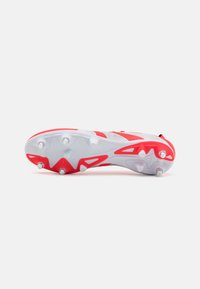 Scarpa da atletica rossa e bianca con un upper testurizzato, otto tacchetti modellati su una suola curva e un logo del marchio ben visibile di lato.