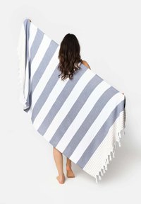 Asciugamano da spiaggia a righe blu e bianche, con bordi frangiati e una consistenza morbida. Progettato per un uso versatile all'aperto.