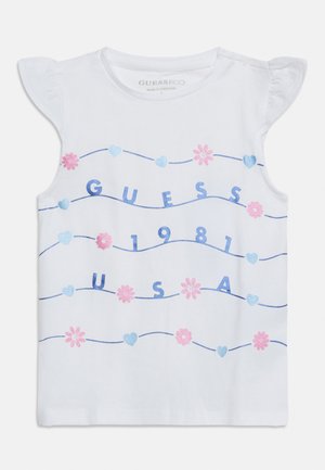 Biele detské tielko bez rukávov s volánikovými ramenami, modrým nápisom "GUESS 1981 USA" a striedajúcimi sa ružovými kvetmi a modrými srdiečkami na vlnitých čiarach.