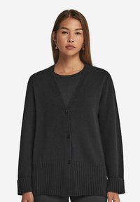 Czarny kardigan wykonany z miękkiego materiału, z dekoltem w kształcie litery V, prążkowanym dołem i mankietami, oraz z przodu zapinany na guziki. Gładka tekstura, luźny krój.