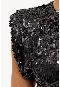 Zwarte top met pailletten, voorzien van een ronde hals, gestructureerde stof en gewatteerde schouders, die een gedurfde, reflecterende uitstraling creëren.