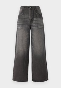 Platās kājas melni džinsi ar izbalējušu apdari, ar divām priekšējām kabatām un kontrastējošām šuvēm. Materiāls ir izturīgs ar teksturētu virsmu.