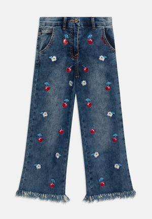 Pantalones vaqueros de mezclilla con bajos deshilachados, decorados con bordados de cerezas rojas y flores azules. Cuenta con bolsillos delanteros y cierre de botones.