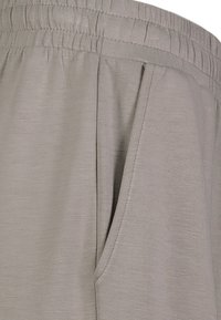 Hellgraue Stoffshorts mit einem elastischen Bund, ausgestattet mit Seitentaschen und einer glatten Textur sowie einem subtilen melierten Muster.