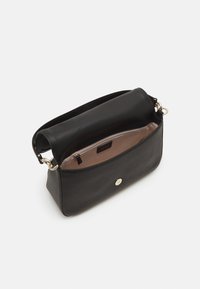 Black leather handbag with a textured exterior and a smooth top section. Features a gold button closure and a light beige interior lining.