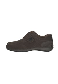 Zapato de ante marrón con una textura suave, que presenta una amplia correa de velcro, punta redondeada y una suela de goma de perfil bajo.