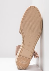 Semelle de sandale espadrille beige montrant une semelle extérieure en caoutchouc texturé, taille 37, marque "Tamaris" et étiquette "Anti Slide" sur le talon.