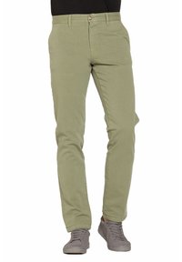 Chinos in cotone verde chiaro con una vestibilità slim, caratterizzati da un'unica chiusura a bottone, tasche laterali e una texture liscia. Abbinati a sneakers grigie.