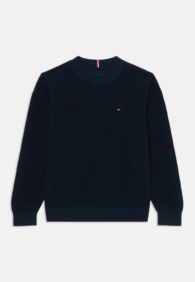 Pull en tricot bleu marine avec un col rond et des poignets côtelés. Présente un petit logo sur la poitrine et un tissu texturé.