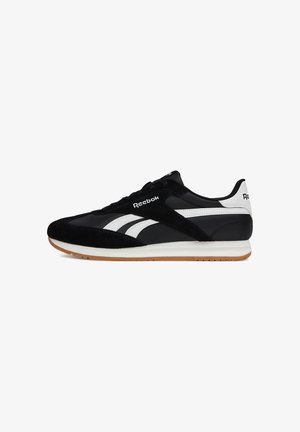 Čierna športová obuv z semišu a syntetických materiálov, so svetlými bielymi detailmi, plochou gumovou podrážkou a klasickým logom Reebok na boku.
