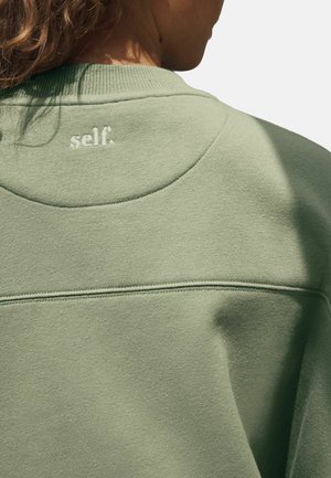 Felpa verde in cotone con scollo rotondo, polsini a costine e la parola "self." ricamata in bianco sulla parte superiore della schiena.