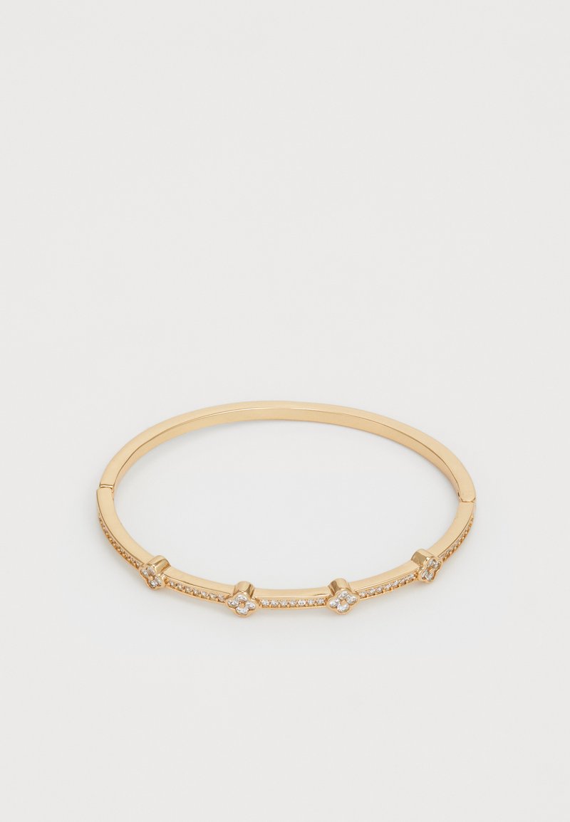 Le bracelet jonc doré présente un design lisse et arrondi avec des cristaux transparents intégrés et des accents floraux sur la surface.