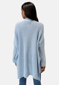Hellblauer, übergroßer Strickcardigan mit einer strukturierten, lockeren Webart, offenem Vorderteil und langen Ärmeln. Mit gerippten Bündchen und Saum.
