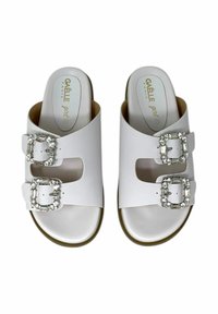 Sandali bianchi slip-on realizzati in materiale sintetico, con due ampie cinghie dotate di fibbie quadrate con cristalli e una soletta imbottita.