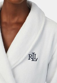Biała szlafrok z froty z kołnierzem szalowym i wyszywanym niebieskim logo "RL" po lewej stronie klatki piersiowej.
