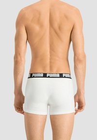 White boxers with black Puma logo waistband; fitted design, smooth texture, and mid-rise cut, viewed from the back.