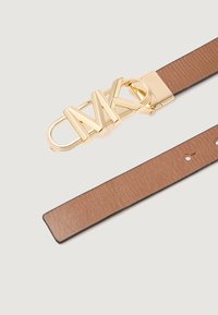 Cinturón de cuero marrón con textura suave, que presenta una gran hebilla con el logo dorado de MK y agujeros ajustables a lo largo de la correa.