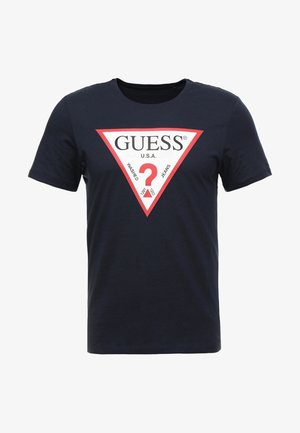 Marineblaues Baumwoll-T-Shirt mit einem großen weißen und roten dreieckigen Grafik, auf der der Text "GUESS U.S.A" und ein Fragezeichen in der Mitte zu sehen sind.