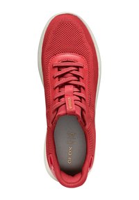 Sneaker rossa in rete con upper texturizzato, lacci piatti e colletto imbottito. Presenta una soletta grigia e una suola in gomma bianca.