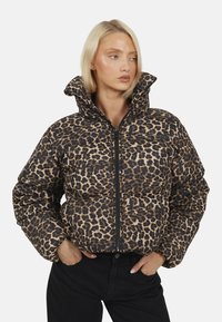 Kurtka puchowa w panterkę z wysokim kołnierzem i zapięciem na zamek. Posiada pikowany wzór w odcieniach beżu i brązu z czarnymi akcentami.