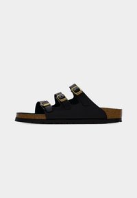 Μαύρο σανδάλι με τρεις ρυθμιζόμενους ιμάντες με χρυσές αγκράφες, πάτο από φελλό και υφή στην σόλα. Ανοιχτός σχεδιασμός για αερισμό και άνεση.