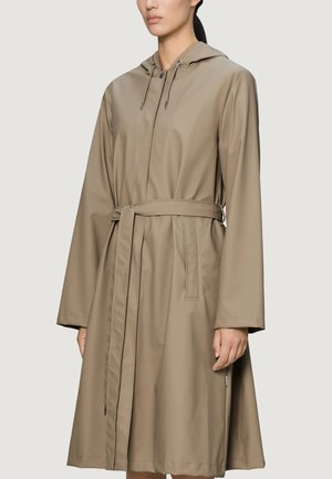 Donna che indossa un impermeabile beige fino al ginocchio con cappuccio, maniche lunghe, tasche frontali, cintura annodata in vita e chiusura con bottoni.