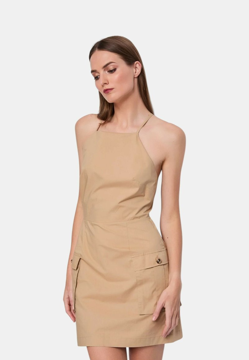 Abito halter color khaki con corpino aderente, tasche laterali e orlo dritto. Realizzato in tessuto leggero, presenta dettagli minimi.