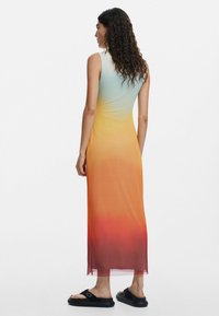 Ärmelloses Maxikleid mit einem Farbverlauf von Hellblau zu Orange und Rot. Hergestellt aus leichtem Stoff, mit einer glatten Textur.