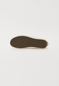 Rubber shoe sole with a textured brown bottom, rounded shape, and light-colored edges. Features a diamond-shaped grip pattern.